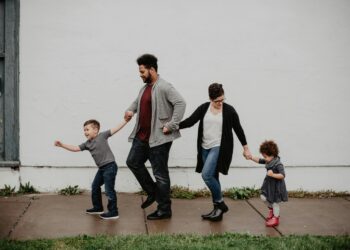 A family of four walking hand-in-hand, enjoying a day out.
